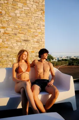 a man and a woman sitting on a couch at Luxury Beachfront Villa - Rooftop Jacuzzi, Sunrise in Paralimni