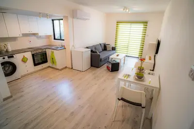 a kitchen and living room with a table and a couch at Cozy Apartment In Kapparis in Paralimni