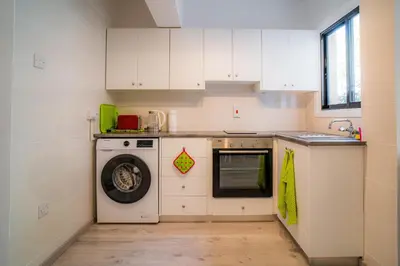 a kitchen with a washing machine and a dishwasher at Cozy Apartment In Kapparis in Paralimni