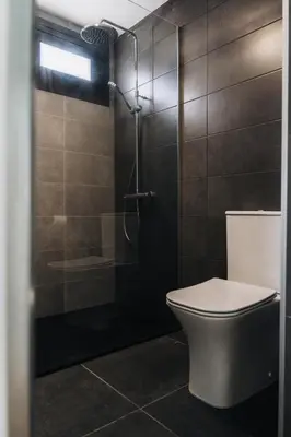 a bathroom with a toilet and a glass shower at Zima Edge in Parekklisha