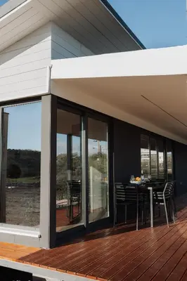 a deck with glass doors and a table with chairs at Zima Edge in Parekklisha