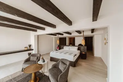 a bedroom with a bed and two chairs at Kaliva Suites - Adults Only in Ayia Napa