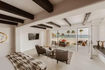 a bedroom with a bed and a view of the beach at Kaliva Suites - Adults Only in Ayia Napa