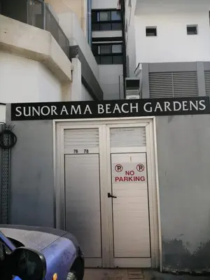 a building with two garage doors with a sign on it at Quattro Beachfront Sea View Ap 206 in Larnaka