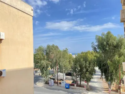 a view of a street with trees and a building at Anastasia Holiday Apartment Larnaca in Larnaka