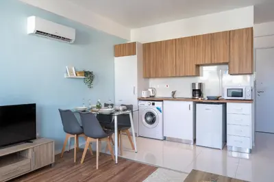 a kitchen with a small table and chairs in a room at Livia Studio Apartment in Larnaca in Larnaka