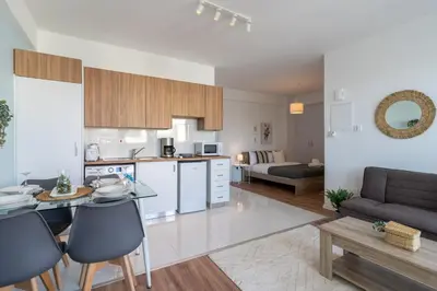 a kitchen and living room with a table and chairs at Livia Studio Apartment in Larnaca in Larnaka