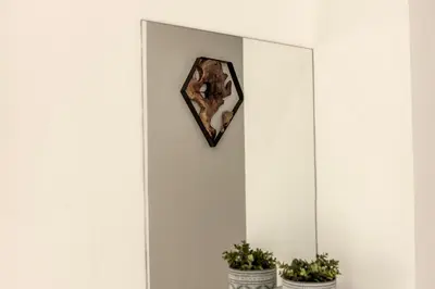 a mirror on a white wall with two potted plants at SEVIS SUITES in Ayia Napa