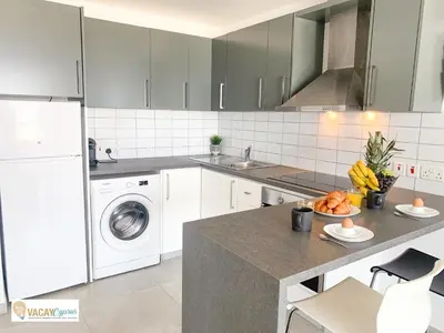 a kitchen with white appliances and a counter with a plate of food at Sea the Sunrise in Larnaka