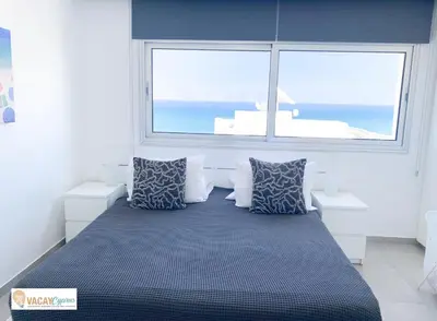 a bed in a room with a large window at Sea the Sunrise in Larnaka