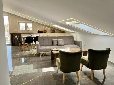 a living room with a couch and a table and chairs at Trendy Loft Apartment in Limassol