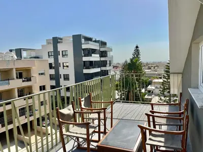 a balcony with chairs and a table and a building at Trendy Loft Apartment in Limassol