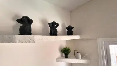 three black figurines sitting on a shelf in a room at Center 2Br Apt w/ parking and 250m walk from beach in Larnaka