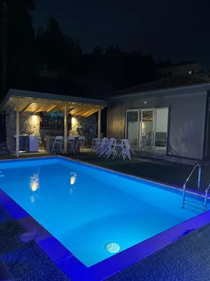 a swimming pool lit up at night at Marianna's House in Galata