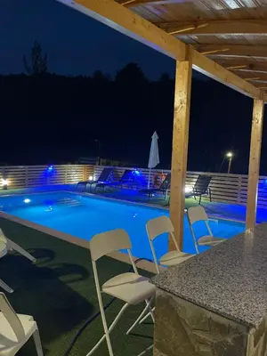 a swimming pool at night with chairs around it at Marianna's House in Galata