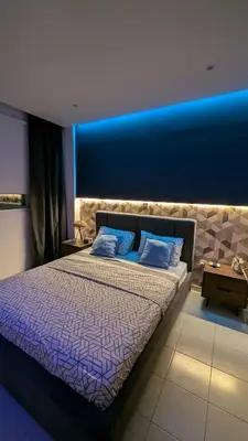 a bedroom with a large bed with a blue wall at Luxury 2-Bedroom Apt. with Seaview in Protaras