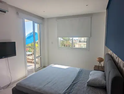 a bedroom with a bed and a window and a television at Luxury 2-Bedroom Apt. with Seaview in Protaras