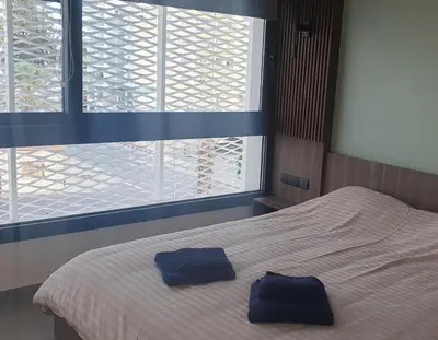 a bedroom with a bed with two blue towels on it at Deluxe 1 Bed Apt Ayios Dometios in Ayios Dhometios