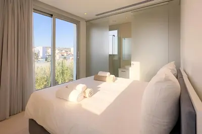 a white bedroom with a large bed with white pillows at City Napa Seaview Villas - Villa 8 in Ayia Napa