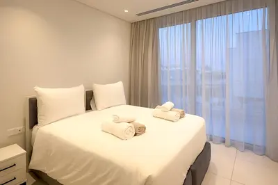 a bedroom with a white bed with towels on it at City Napa Seaview Villas - Villa 8 in Ayia Napa