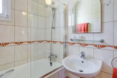 a bathroom with a sink and a mirror and a tub at Villa Niki in Ayia Napa