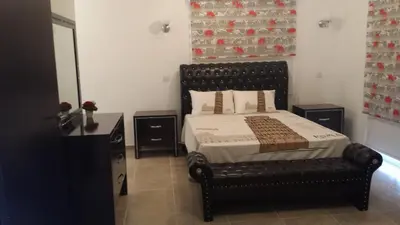 a bedroom with a bed with a black leather bed frame at Villa Melyia in Kato Pyrgos