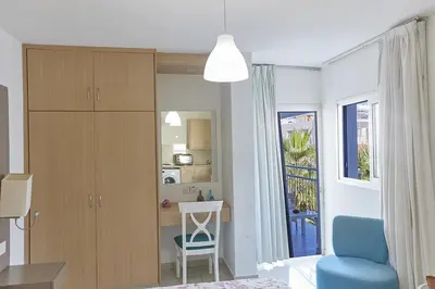 a living room with a table and a chair and a kitchen at Napa Hera 's Nest in Ayia Napa