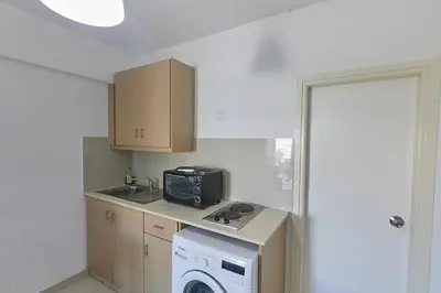 a kitchen with a microwave and a washing machine at Napa Hera 's Nest in Ayia Napa