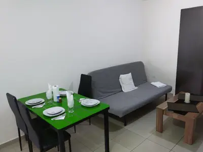 a living room with a green table and a couch at 2br-7 Guests-Free Parking-Pool-AirCon in Paralimni