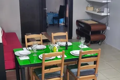 a dining room table with a green tablecloth and chairs at 2br-7 Guests-Free Parking-Pool-AirCon in Paralimni