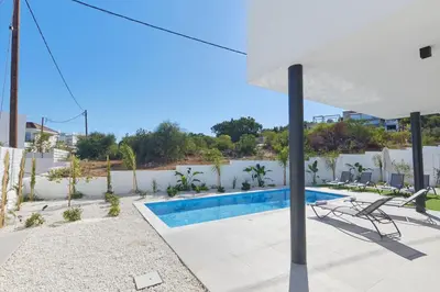 a villa with a swimming pool and an umbrella at Protaras Elite Pearl Villa Ep4b in Protaras