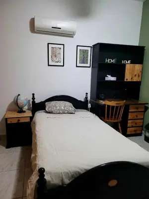 a bedroom with a bed and a desk with a fan at Beautiful bedroom in Limassol