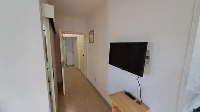 a flat screen tv hanging on a white wall at Seaside 2BR Apartment 30m from Sea & Free Parking in Voroklini