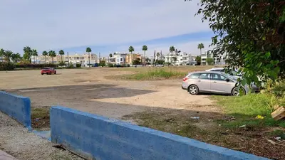 a car parked in a parking lot with buildings in the background at Seaside 2BR Apartment 30m from Sea & Free Parking in Voroklini