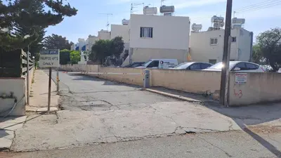 a street with cars parked next to a fence at Seaside 2BR Apartment 30m from Sea & Free Parking in Voroklini
