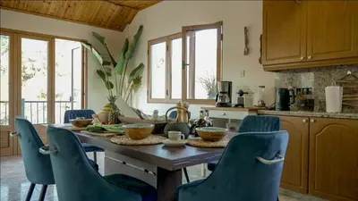 a kitchen with a wooden table and blue chairs at Mountain Retreat in Troodos