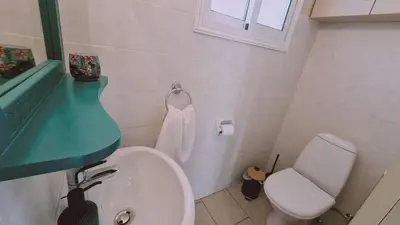 a bathroom with a white toilet and a green counter at STAY Naturaleza Penthouse in Limassol