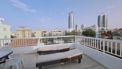 a balcony with a table and chairs and a view of a city at STAY Naturaleza Penthouse in Limassol