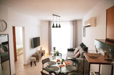 a living room with a table and a couch at Sunrise Beach Apartments in Larnaka