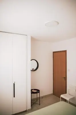 a bedroom with a sliding door and a chair at Sunrise Beach Apartments in Larnaka