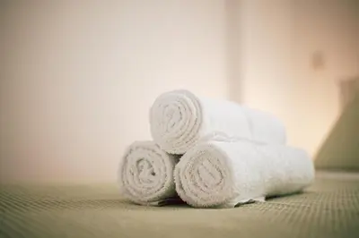 a pile of white towels sitting on a bed at Sunrise Beach Apartments in Larnaka