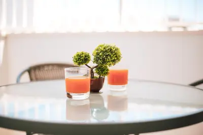 two glasses of orange juice sitting on a glass table at Sunrise Beach Apartments in Larnaka
