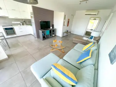 a living room with a blue couch and a kitchen at Panoramic Sea View Apt - 2bed in Limassol