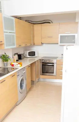 a kitchen with wooden cabinets and a dishwasher at Seaview Apartment (Excellent Location) in Larnaka