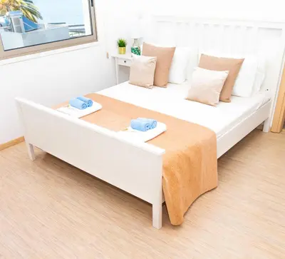 a bedroom with a large white bed with two towels on it at Seaview Apartment (Excellent Location) in Larnaka