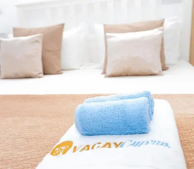 two beds with white and blue pillows in a room at Seaview Apartment (Excellent Location) in Larnaka