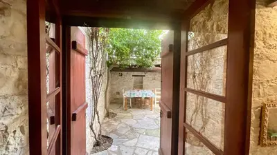 an open door to a patio with a table outside at Juliet Suite by TrulyCyprus in Doros
