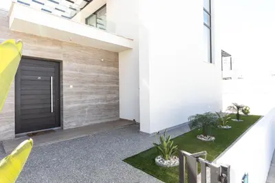 a garage with a black door and some plants at Luxury Panorama Villa Protaras in Protaras