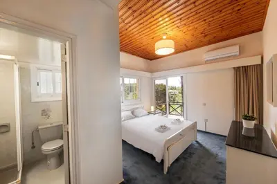 a bedroom with a bed and a toilet and a bathroom at Platres Forest Panorama Cottage in Platres