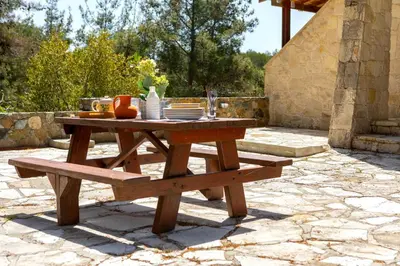 a wooden picnic table and bench on a patio at Platres Forest Panorama Cottage in Platres